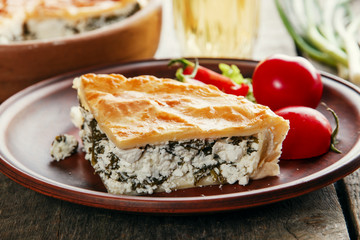 homemade pie with feta cheese and spinach in a clay bowl