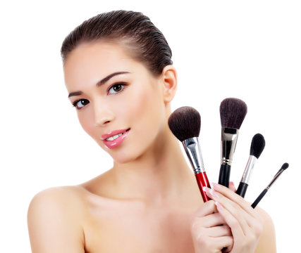 Pretty woman with makeup brushes