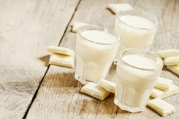 White chocolate mousse in small cups and pieces of chocolate on