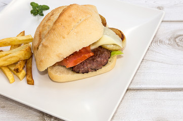Burger with cheese, tomato, lettuce and chips