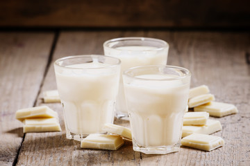 White chocolate mousse in small cups and pieces of chocolate on