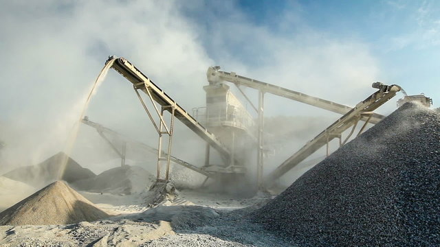 Industrial background - crusher (rock stone crushing machine) at open pit mining and processing plant for crushed stone, sand and gravel