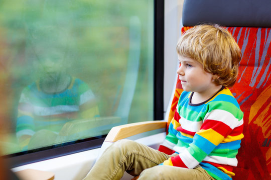 Little boy sitting in train and going on vacations