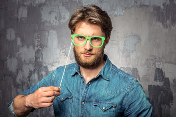 Young handsome man holding paper green glasses