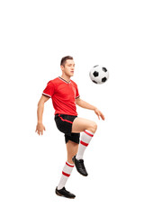 Young football player juggling a ball