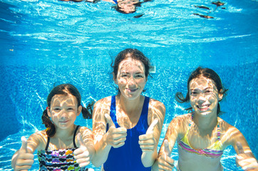 Family swim in pool underwater, happy active mother and children have fun in water, kids sport on...