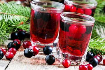 Winter drink with cranberry, cowberry and black chokeberry on th