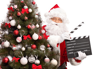 Santa Claus holding a movie clapperboard