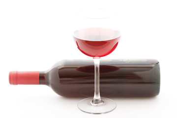 Glass and bottle of red wine unusually on white background.