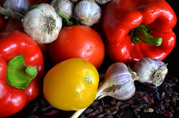 still life of fresh vegetables and dried barberry with drops of water on a dark background

