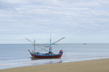 Naklejka na ściany i meble Beautiful ocean beach an fishing boat