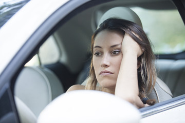 Bored woman waiting patiently in her car