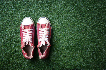 a red shoes on the lawn - obrazy, fototapety, plakaty