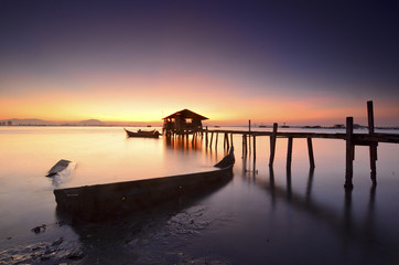 Fototapeta na wymiar Silhouette of fisherman cottage during sunrise