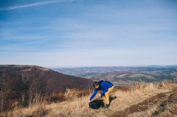 Handsome young man standing on a rock, enjoying the view