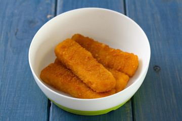 fish in small bowl on blue wooden background