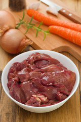 chicken liver in white bowl with carrot and onion
