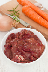 chicken liver in white bowl with carrot, garlic and onion