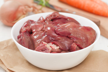 chicken liver in white bowl with carrot, garlic