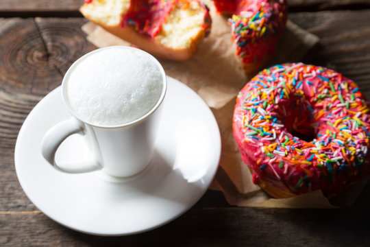 Cappuccino and donuts on a wooden table