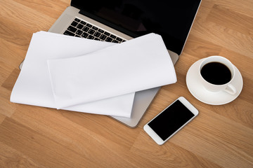 laptop with coffee cup  and smart phone,newspaper on wood table