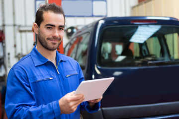 Young attractive mechanic working at the garage