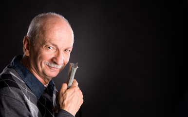 Happy elderly man showing dollars