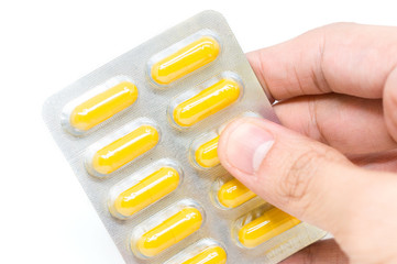 Yellow herb capsules in aluminum blister pack