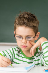 Netter Junge malt in der Schule ein Bild