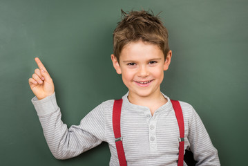 Kleines Kind deutet mit Zeigefinger auf Tafel