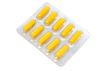 yellow pills in blister pack isolated on white background