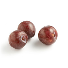 Trio of Red Plums on White Background