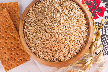 Oats in wooden bowl and bread from oats
