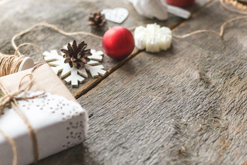 Cozy vintage toned winter holidays Christmas Composition with Gifts Boxes and Balls, Pine Cones Wooden Background