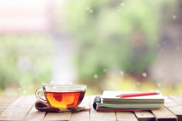 tea in glass and notebook with pencil at windows