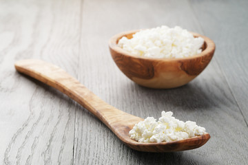 fresh cottage cheese in a wood bowl on a wooden table