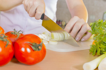 Closeup of knife slicing vegetables 