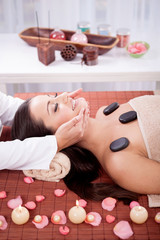 Fototapeta na wymiar Beautiful woman having a wellness facial massage at spa salon