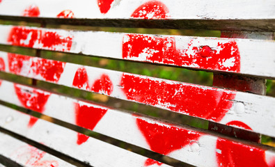 Red hearts painted on a white wooden bench
