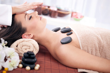 Beautiful woman having a wellness head massage at spa salon