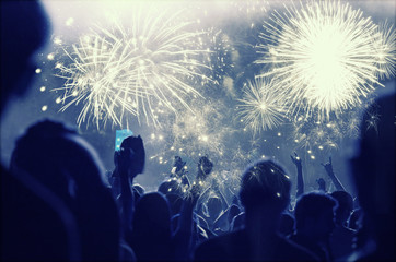 New Year concept - cheering crowd and fireworks