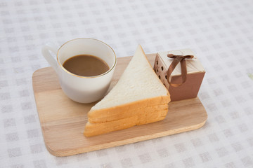 A cup of coffee with sandwich and gift