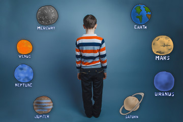Teenage boy standing with his back planets of the solar system a