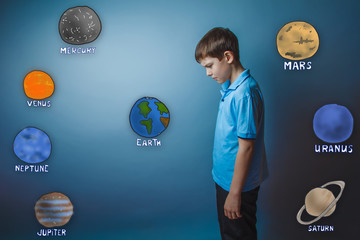 teenager boy standing sideways with his head down and looks at t