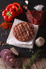 Raw burgers cutlets close-up with the ingredients. vertical top view
