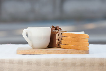 A cup of coffee with sandwich and gift