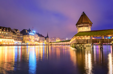 Fototapeta na wymiar Lucerne, Switzerland, night view over the Reuss river to the wooden Chapel bridge