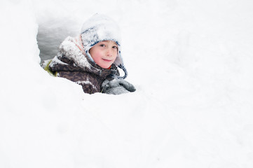 Fototapeta na wymiar young boy playing out in a snowfort on a winter day