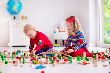 Children playing with toy railroad and train