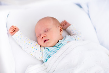 Cute newborn baby in white bed